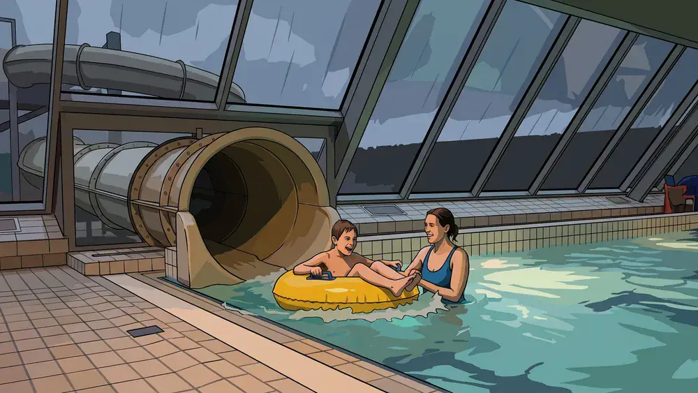 Freizeitbad Wasserwelt in Braunschweig – Kind rutscht im Reifen ins Becken, während der Regen aufs Glasdach der Halle prasselt